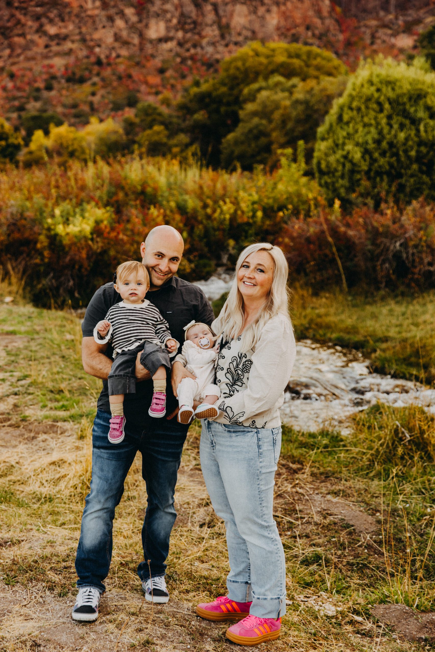 Family portrait session in Salina, Utah with parents and children smiling outdoors Central Utah family photography session during golden hour in Sevier County Family of five posing in a mountain meadow near Richfield, Utah Extended family portrait session in Sanpete County, Utah