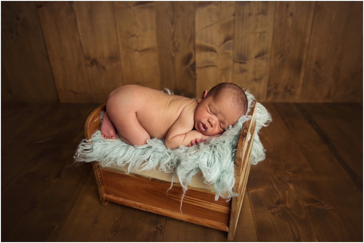 orange-studio-newborn-photographer baby in a bed